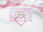 Bordkort holder hjerte i rosa guld